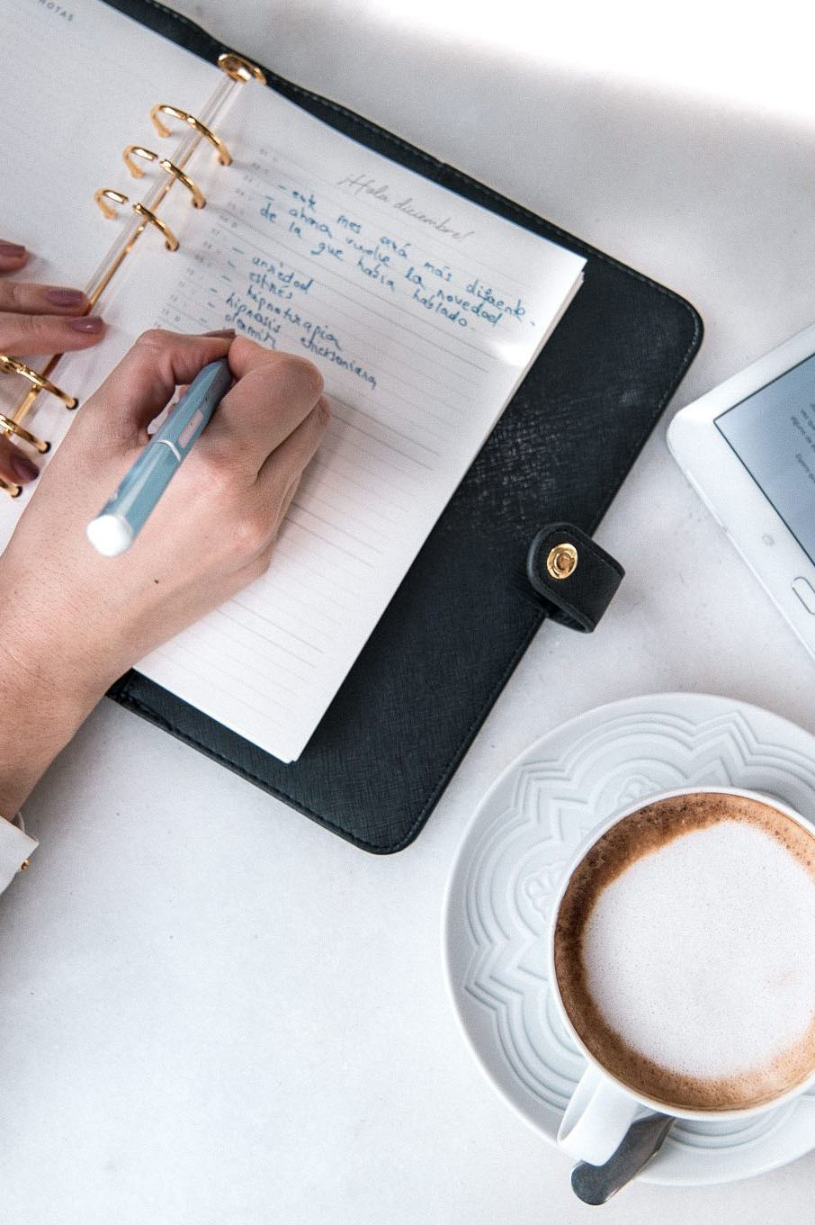 Cuaderno y café sobre una mesa durante la planificación de una sesión
