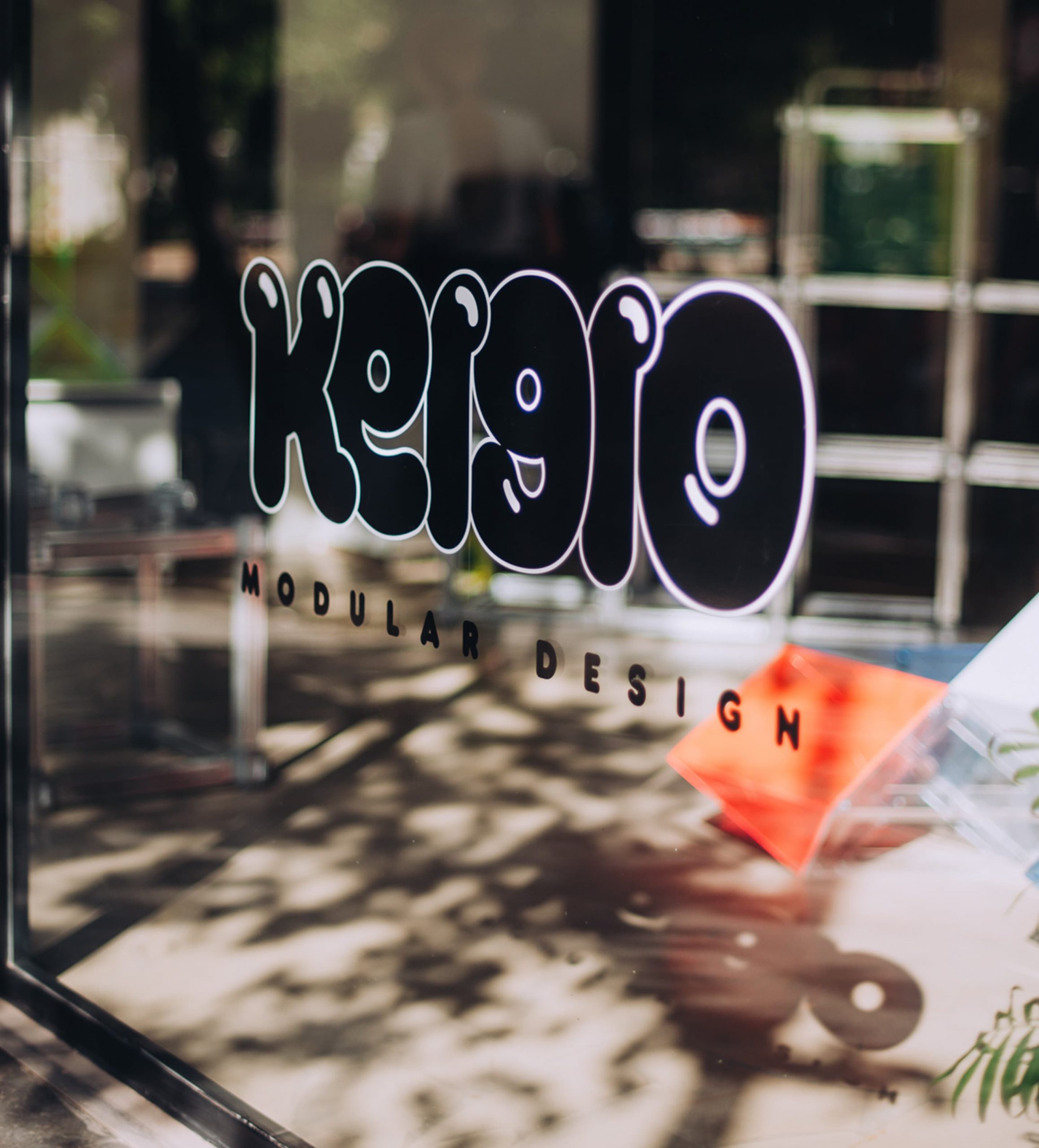 Rótulo de Keigio Modular Design en el cristal del taller