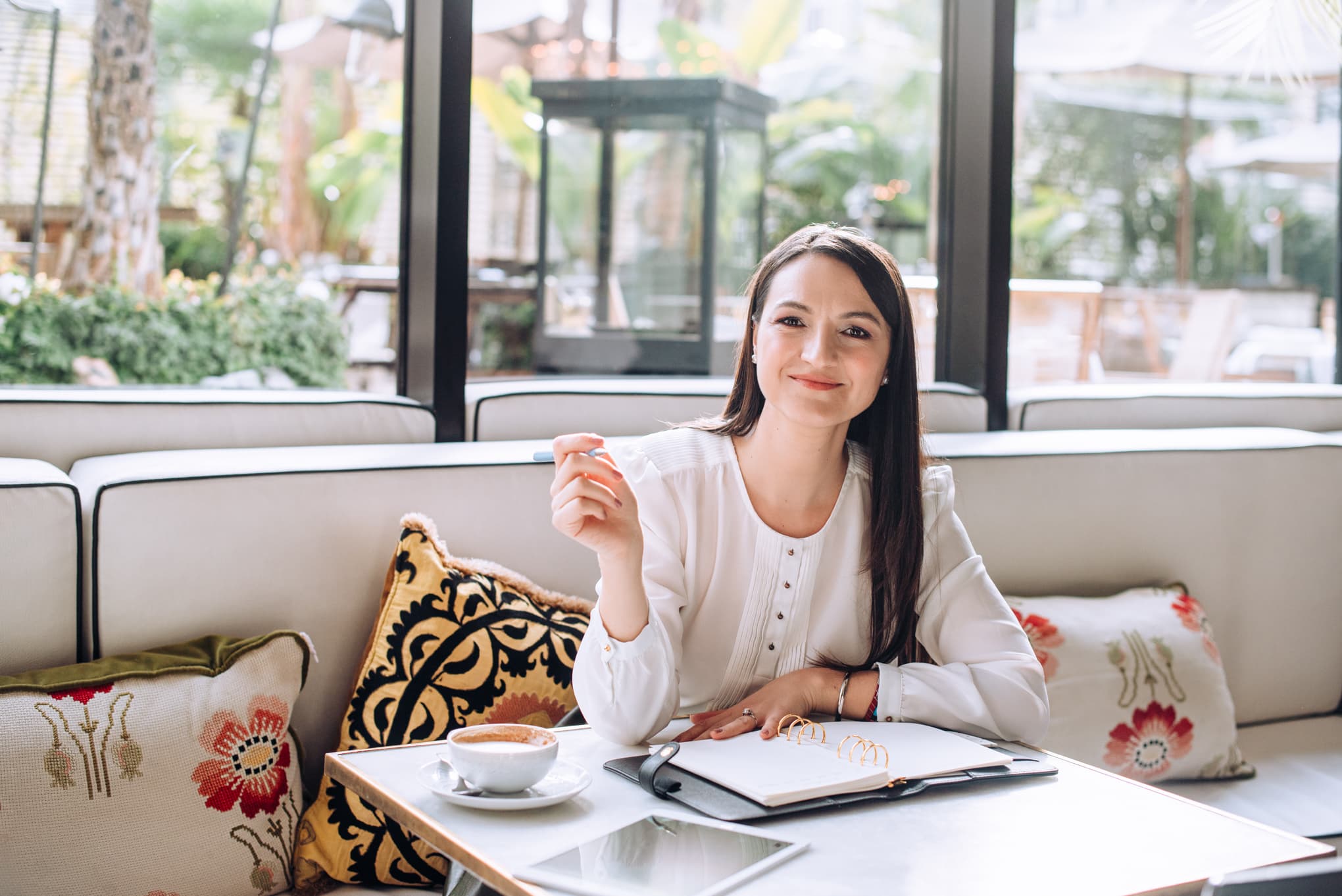 Mujer con agenda y café en una cafetería luminosa