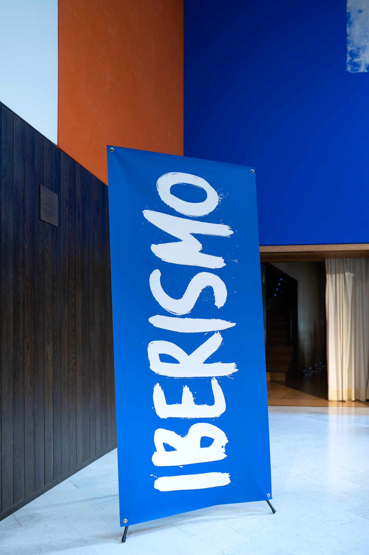 Roll-up azul con el rótulo Iberismo en la entrada del acto
