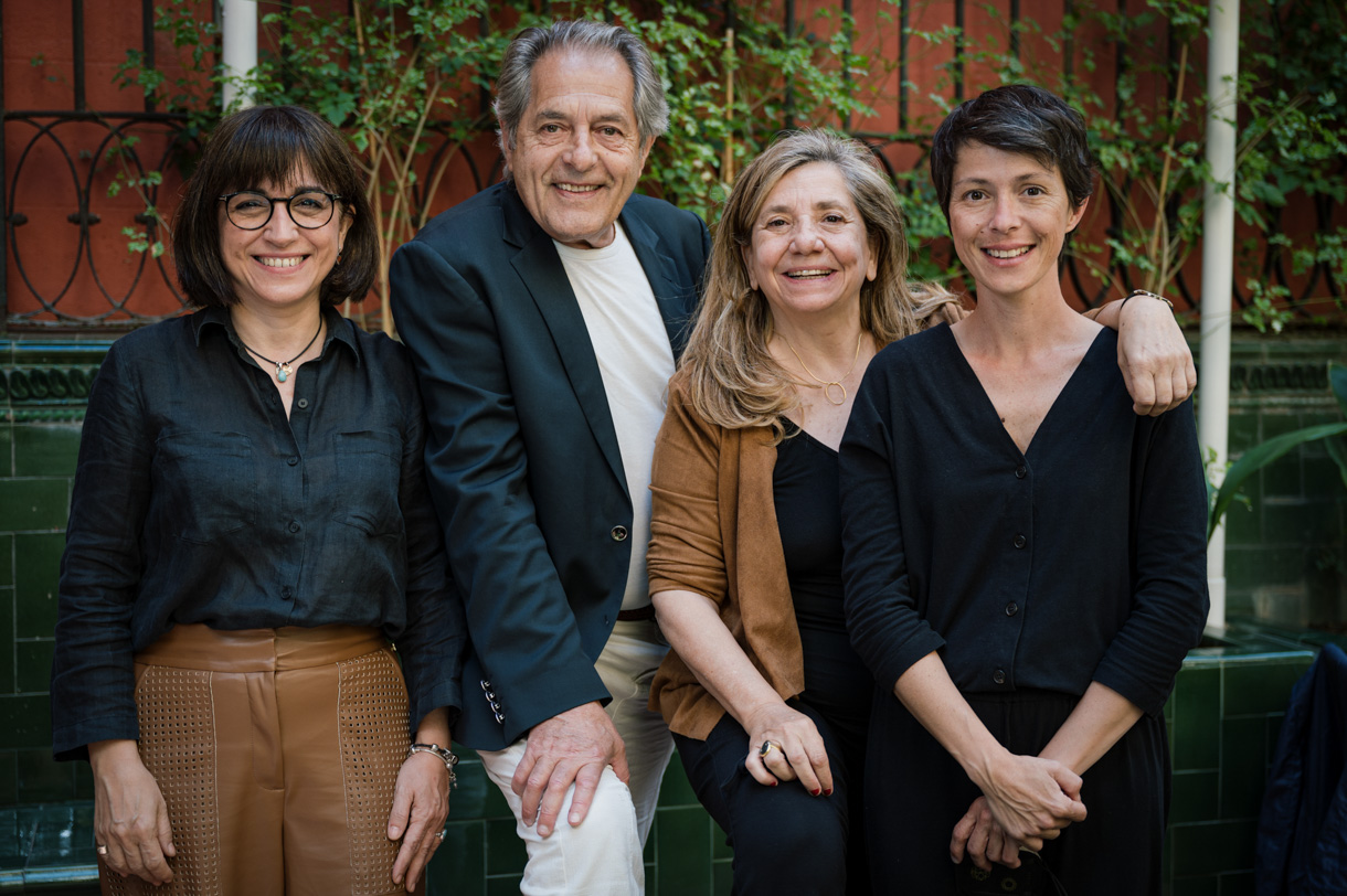 Cuatro personas del equipo organizador posando en un patio ajardinado