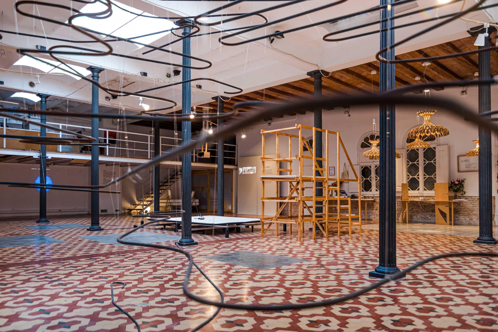Instalación cinética de líneas suspendidas entre las columnas de la sala