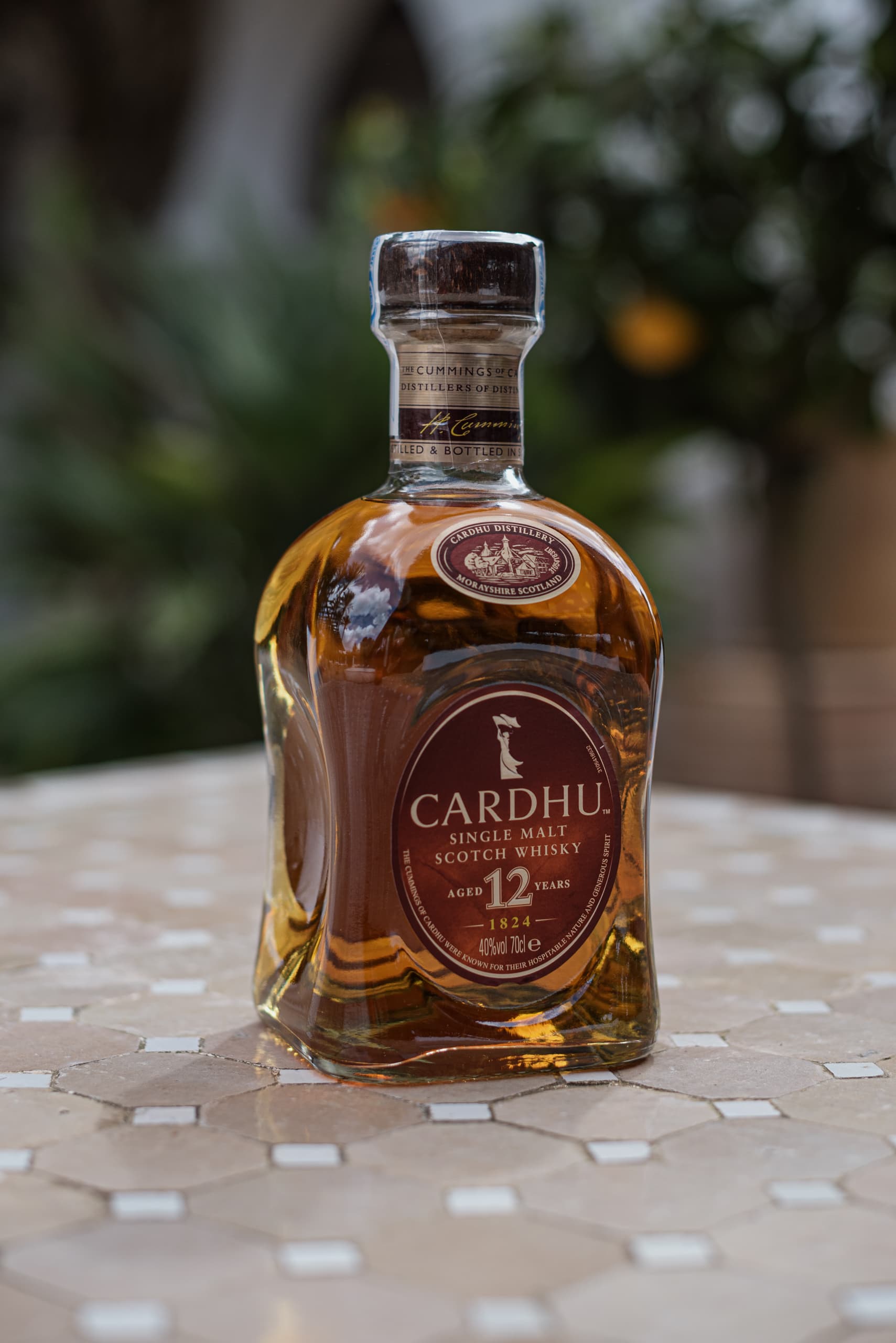 Botella de whisky Cardhu de 12 años sobre una mesa exterior